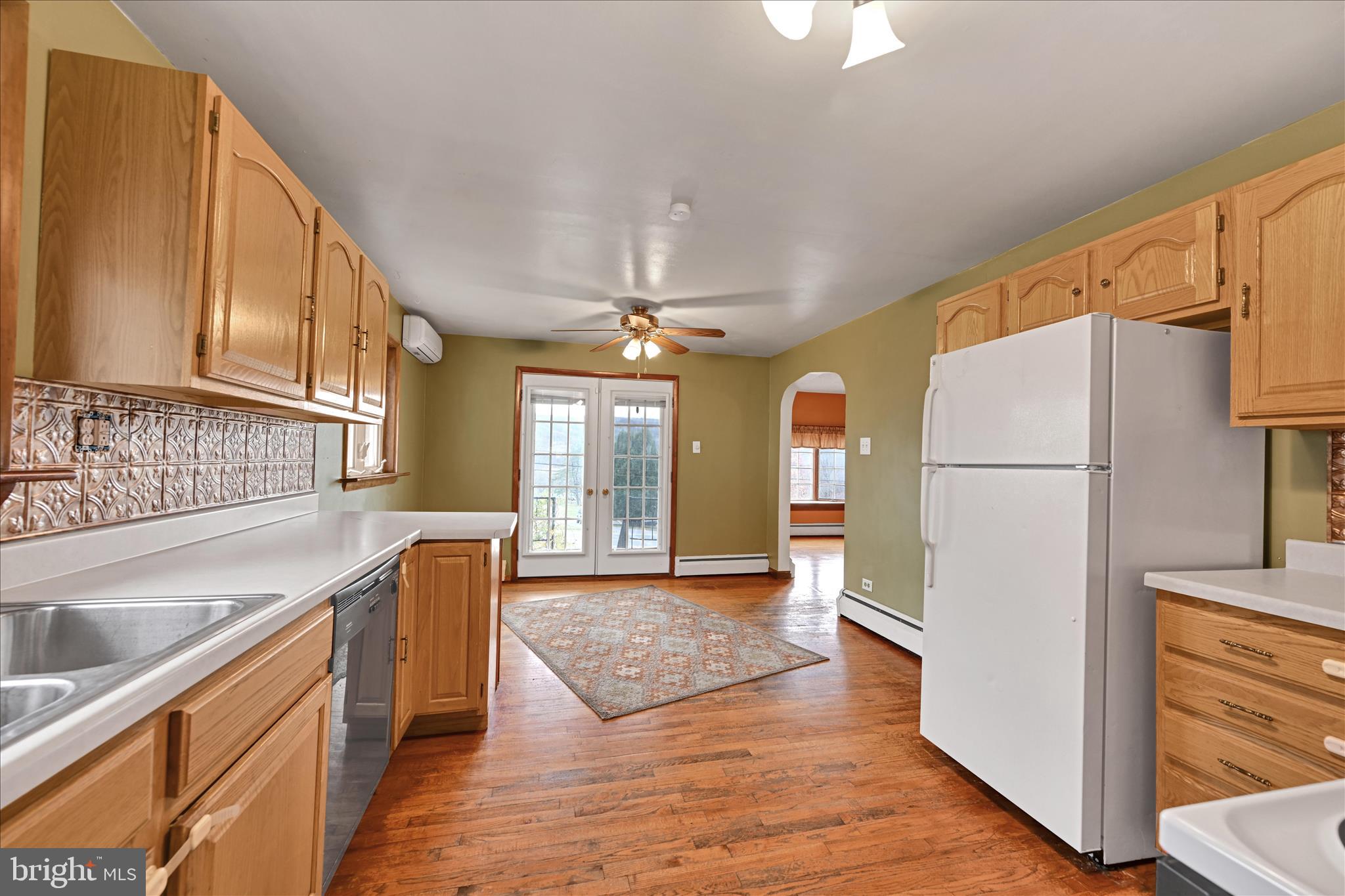 1012 Fountain Street Ashland, PA 17921 - Photo 11 of 34 a kitchen with stainless steel appliances granite countertop a refrigerator a sink dishwasher a stove and a dining table with wooden floor