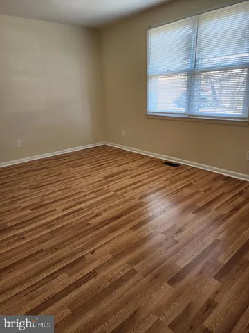 a view of a room with wooden floor and window