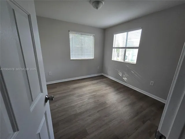 a view of a room with wooden floor and windows