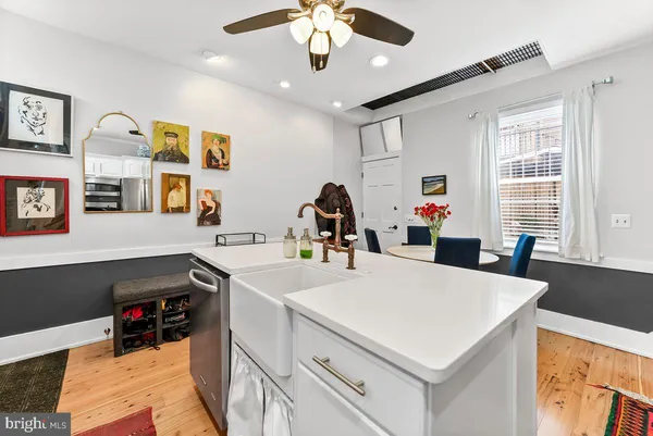 a dining room with stainless steel appliances kitchen island granite countertop a dining table chairs and a refrigerator