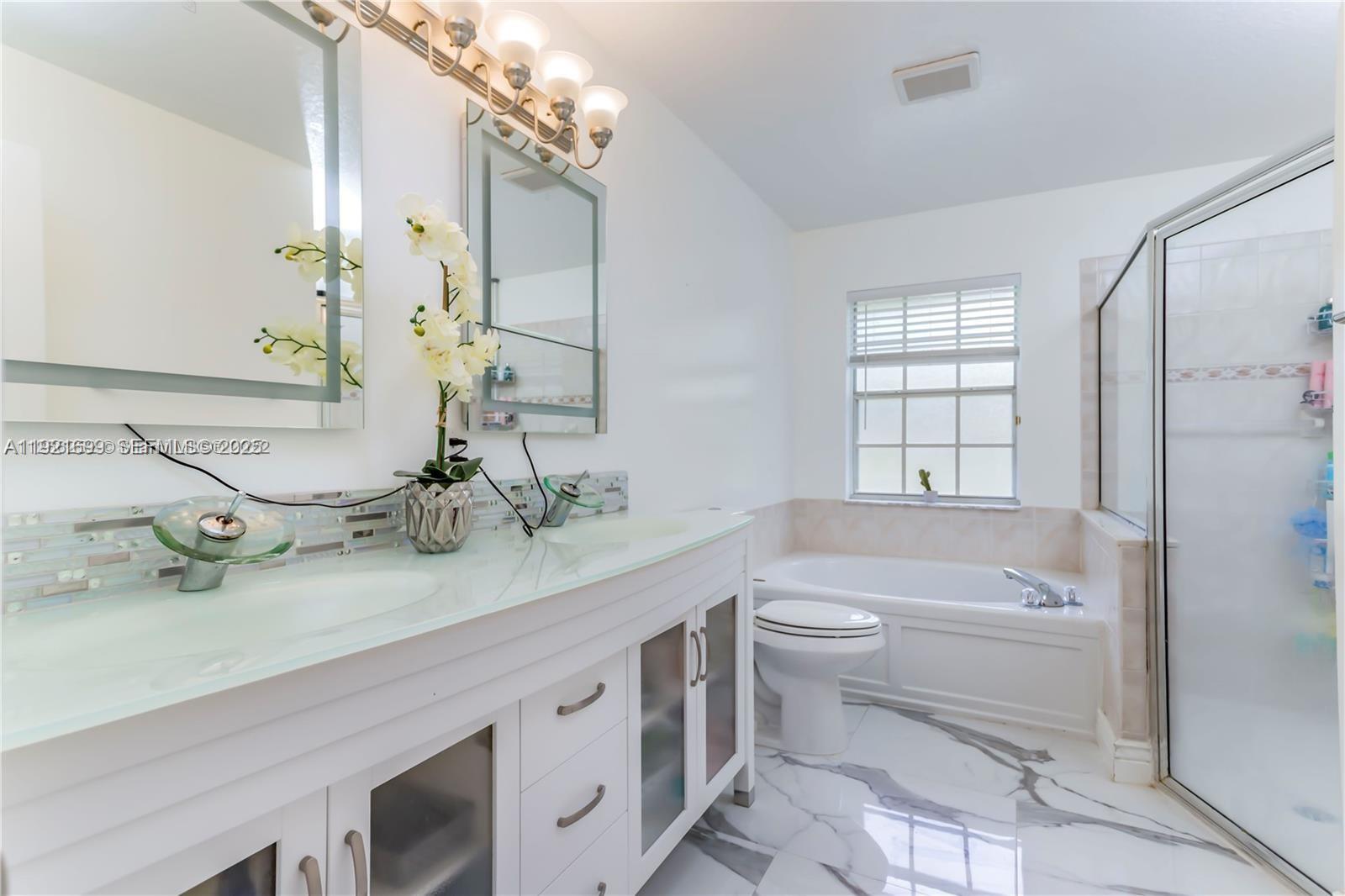17996 North 42nd Road North Loxahatchee, FL 33470 - Photo 12 of 34 a bathroom with a double vanity sink toilet mirror and bathtub