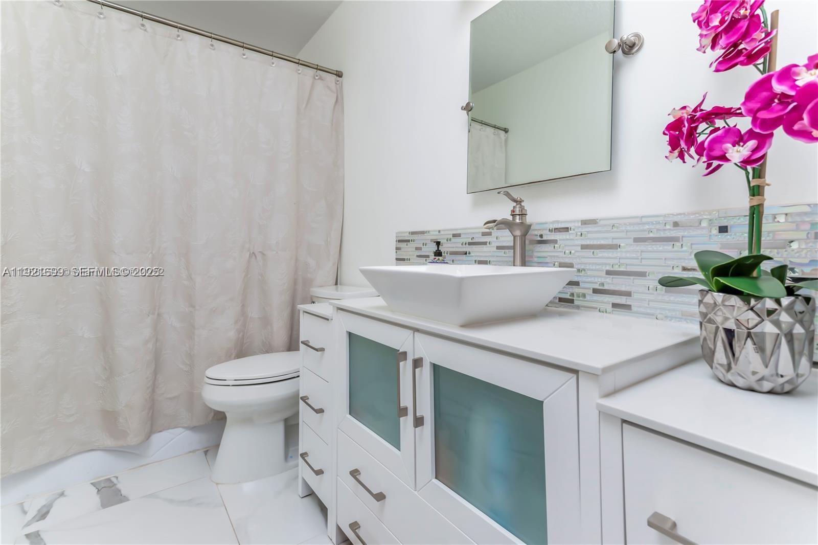 17996 North 42nd Road North Loxahatchee, FL 33470 - Photo 16 of 34 a bathroom with a sink a toilet and a mirror