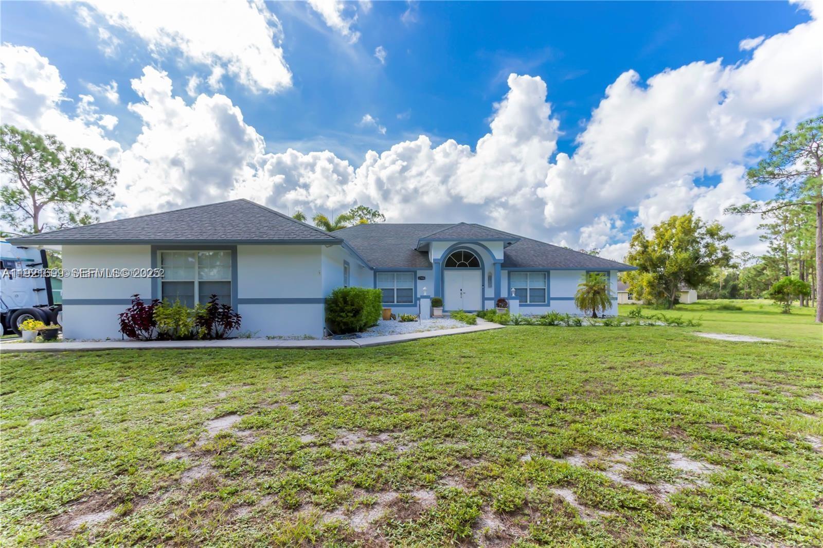 17996 North 42nd Road North Loxahatchee, FL 33470 - Photo 2 of 34 a view of a house with a yard porch and sitting area