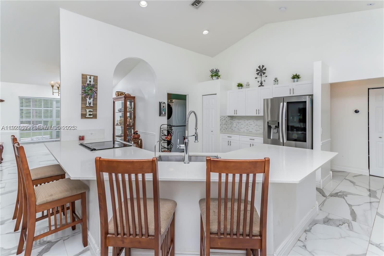 17996 North 42nd Road North Loxahatchee, FL 33470 - Photo 7 of 34 a dining room with kitchen island a table and chairs