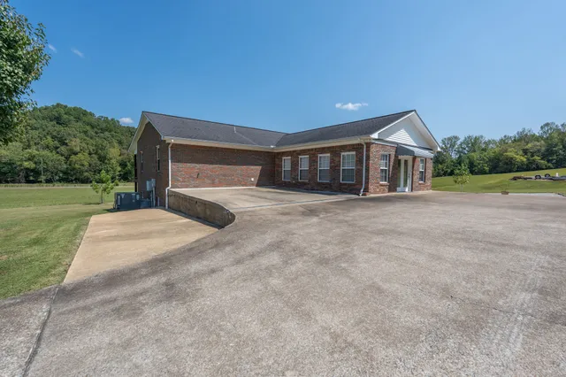 a view of a house with backyard and trees