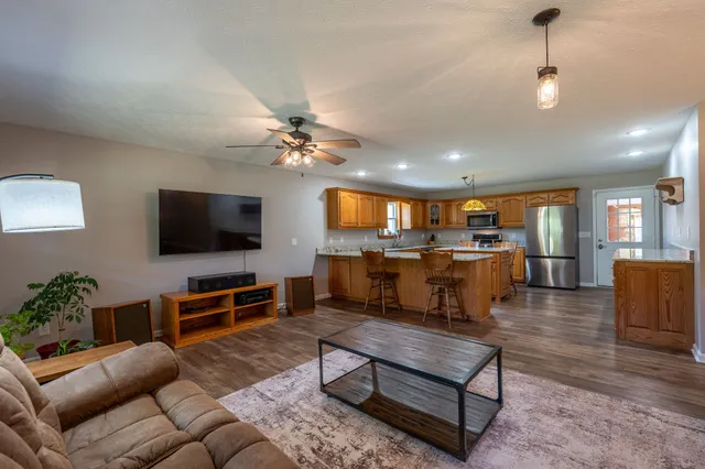 a living room with furniture kitchen view and a flat screen tv