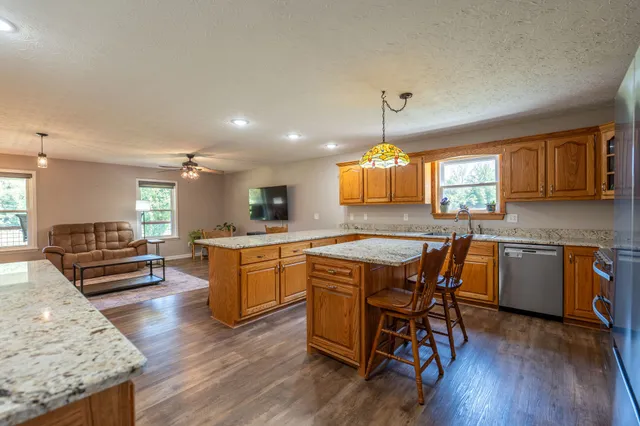 a kitchen with a table chairs wooden floors and a view of living room