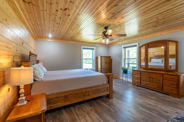a bedroom with a large bed and wooden floor