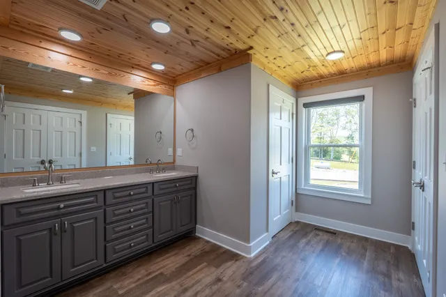 a spacious bathroom with a granite countertop sink and a large mirror