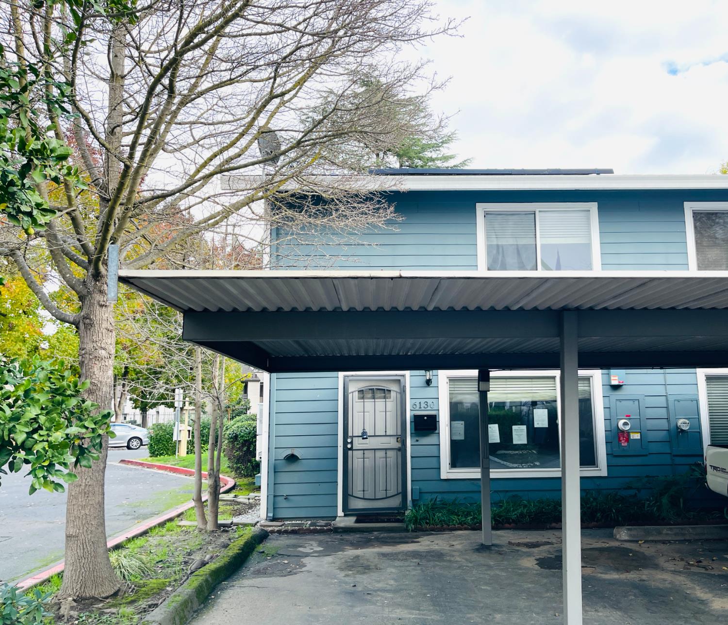 a view of a house with a large window and wooden fence