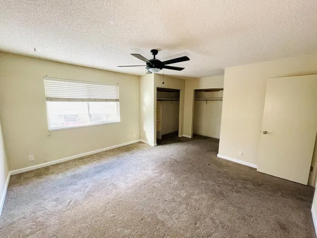 a view of a livingroom with a ceiling fan and window