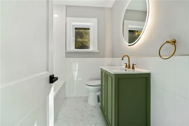 a bathroom with a toilet sink and mirror