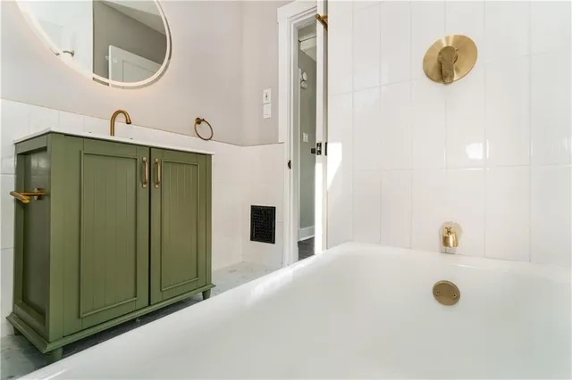 a bathroom with a tub sink and mirror