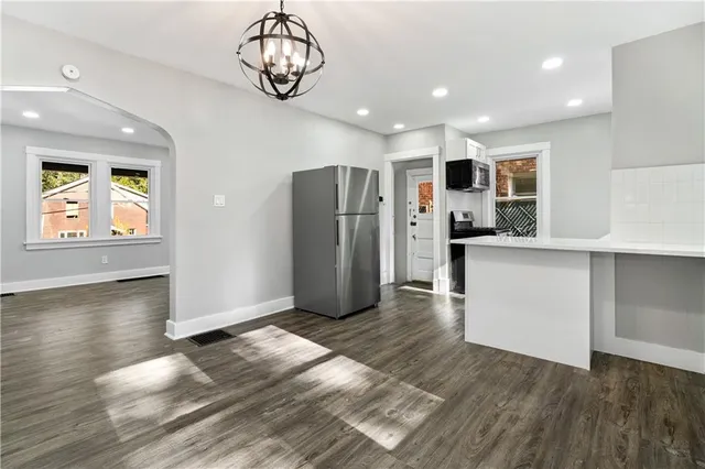 a view of a kitchen with wooden floor and a refrigerator