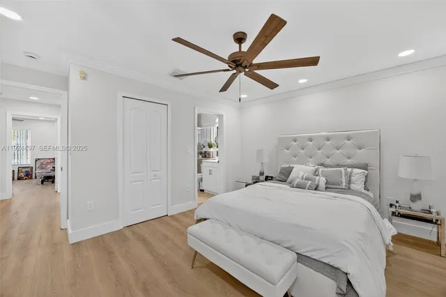 a bedroom with a large bed and wooden floor