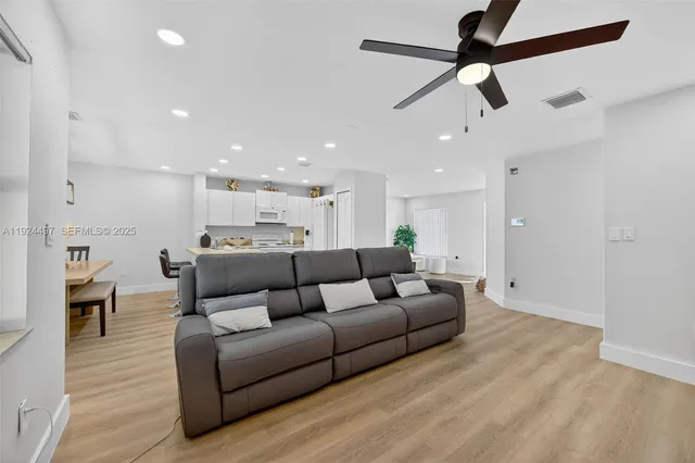 a living room with furniture and a ceiling fan