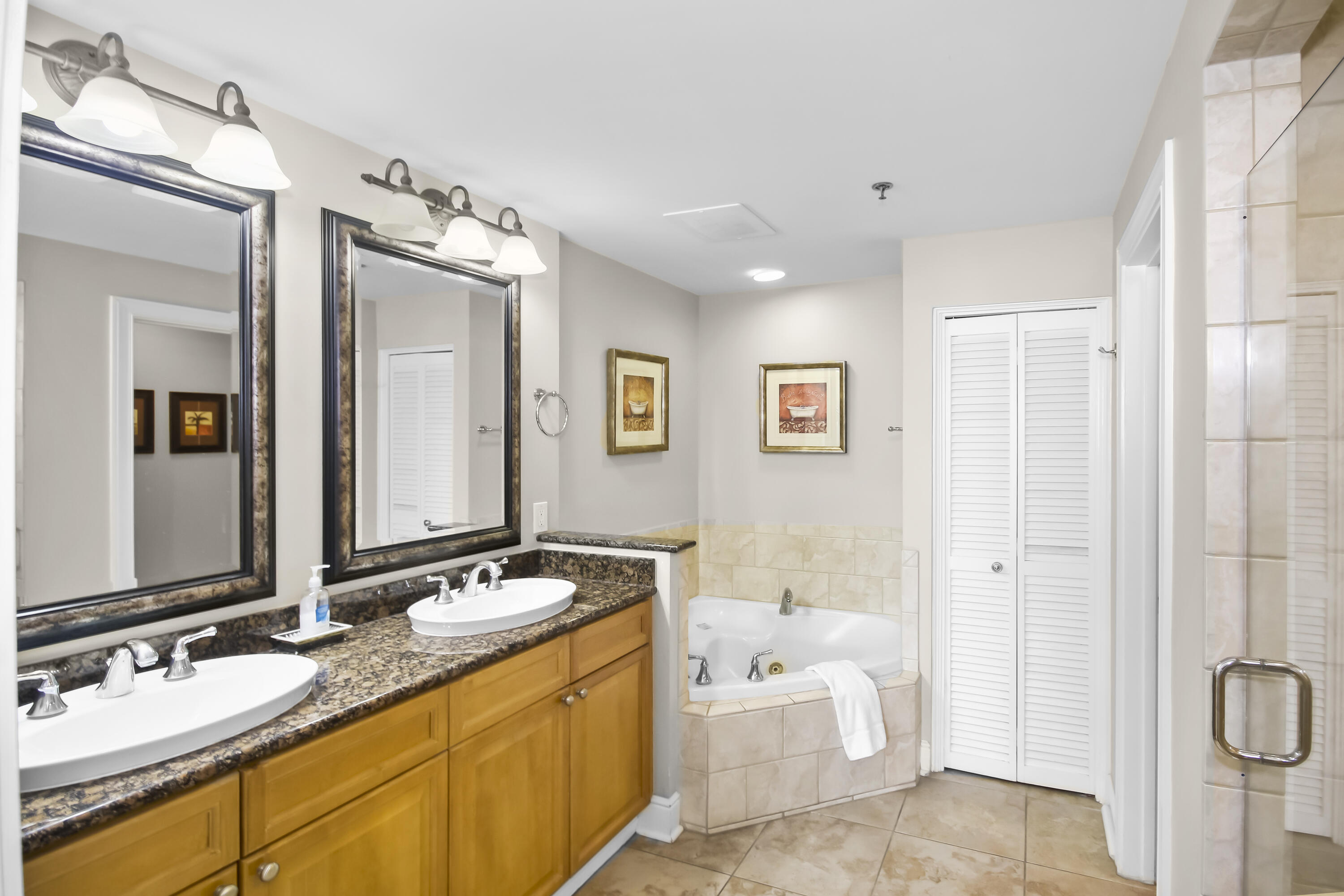 1150 Santa Rosa Boulevard, Unit 502 Fort Walton Beach, FL 32548 - Photo 13 of 43 a spacious bathroom with a granite countertop tub sink and mirror