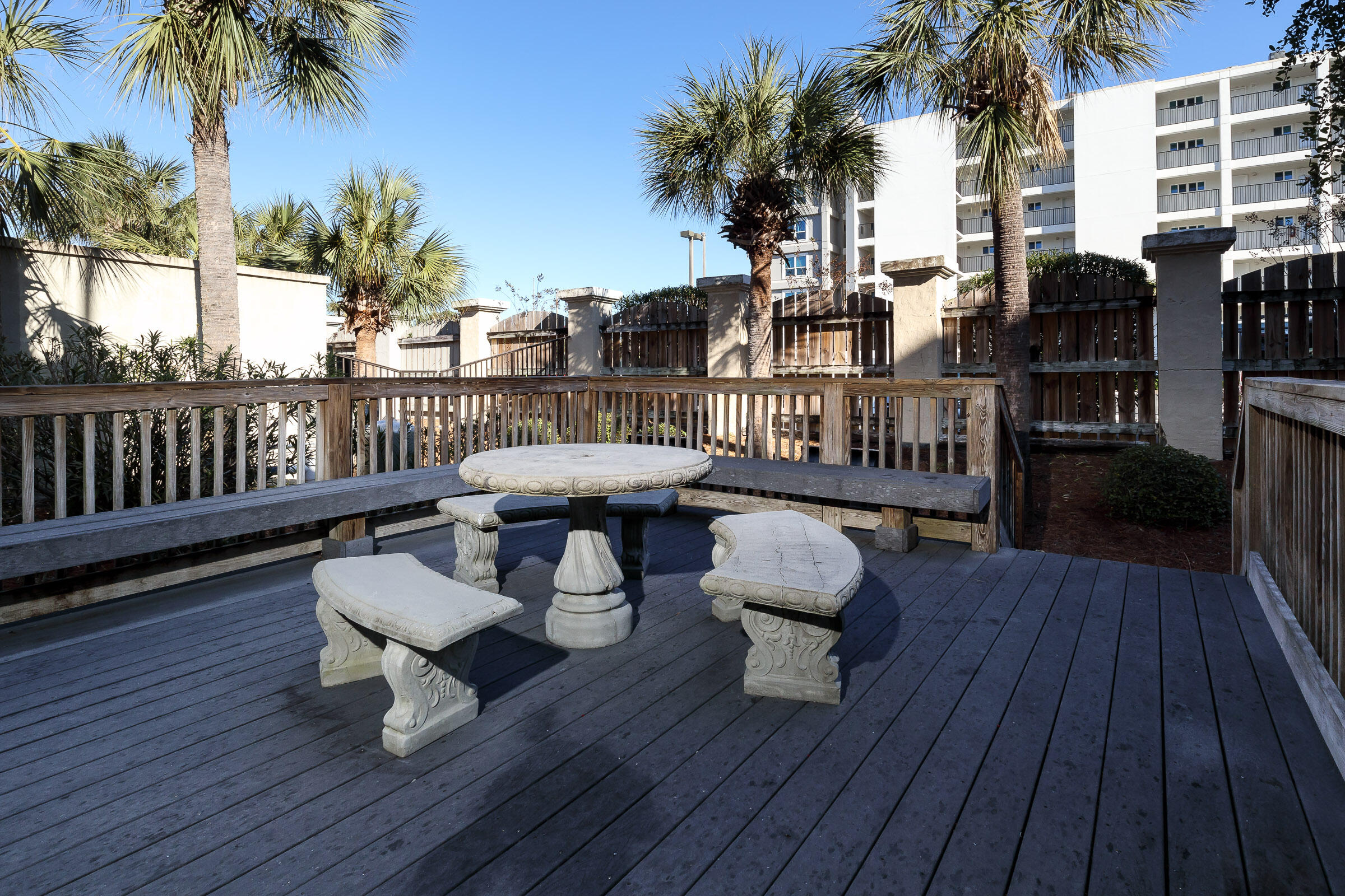 1150 Santa Rosa Boulevard, Unit 502 Fort Walton Beach, FL 32548 - Photo 36 of 43 a view of a roof deck with table and chairs couches and a barbeque with wooden floor
