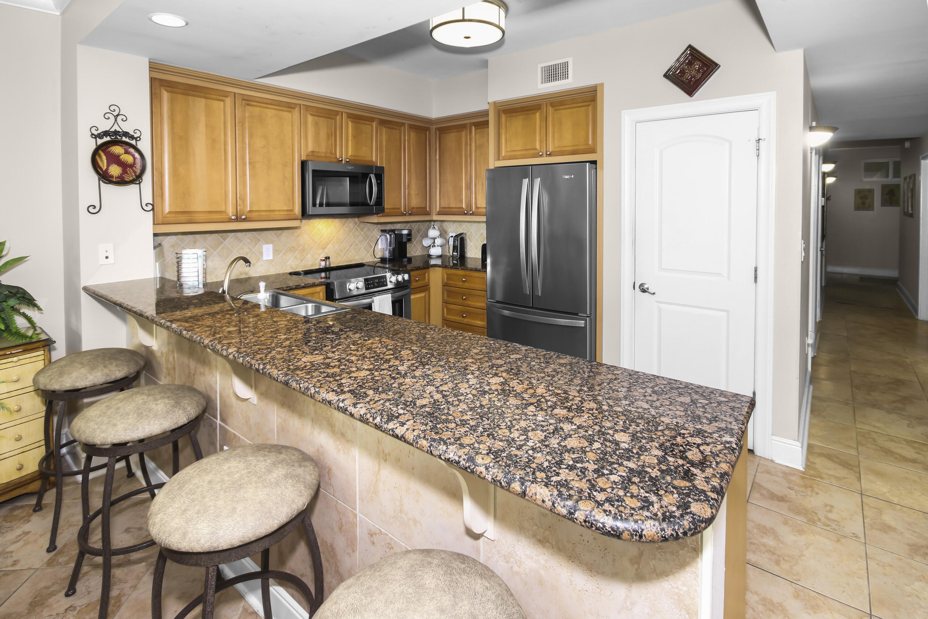 1150 Santa Rosa Boulevard, Unit 502 Fort Walton Beach, FL 32548 - Photo 8 of 43 a kitchen with stainless steel appliances granite countertop a sink refrigerator and cabinets