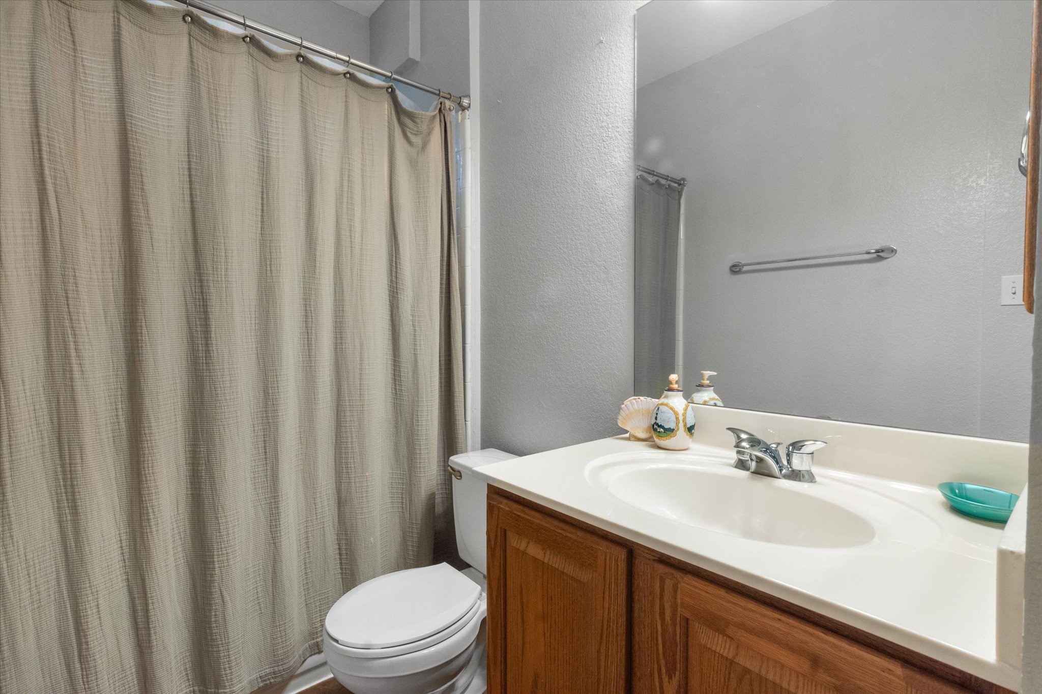 11000 Anderson Mill Road, Unit 34 Austin, TX 78750 - Photo 13 of 18 a bathroom with a sink a toilet and shower curtain
