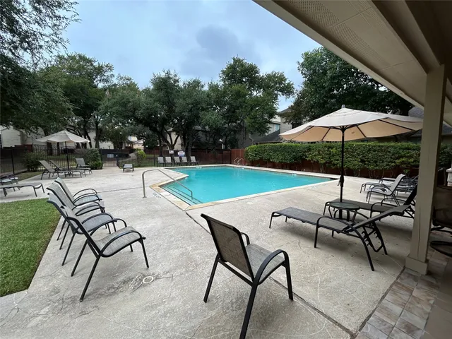 a view of a patio with chairs and table under an umbrella