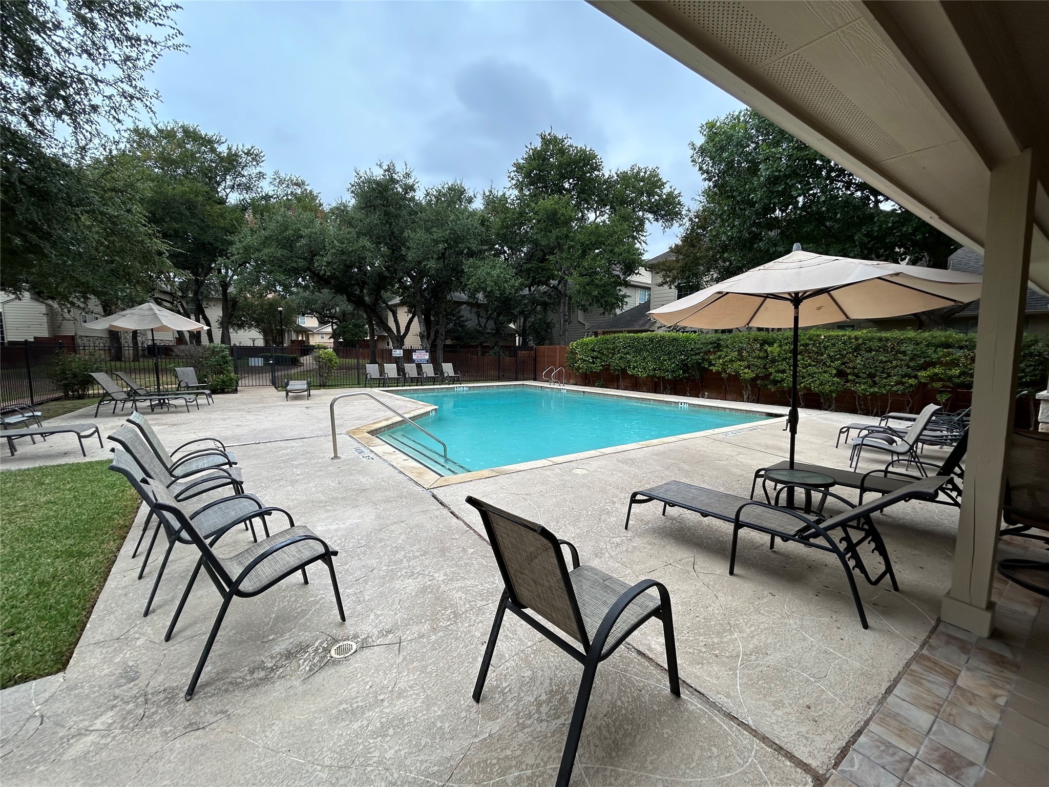 11000 Anderson Mill Road, Unit 34 Austin, TX 78750 - Photo 16 of 18 a view of a patio with chairs and table under an umbrella