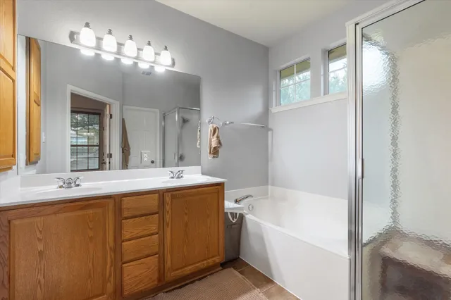 a bathroom with a tub a sink and mirror