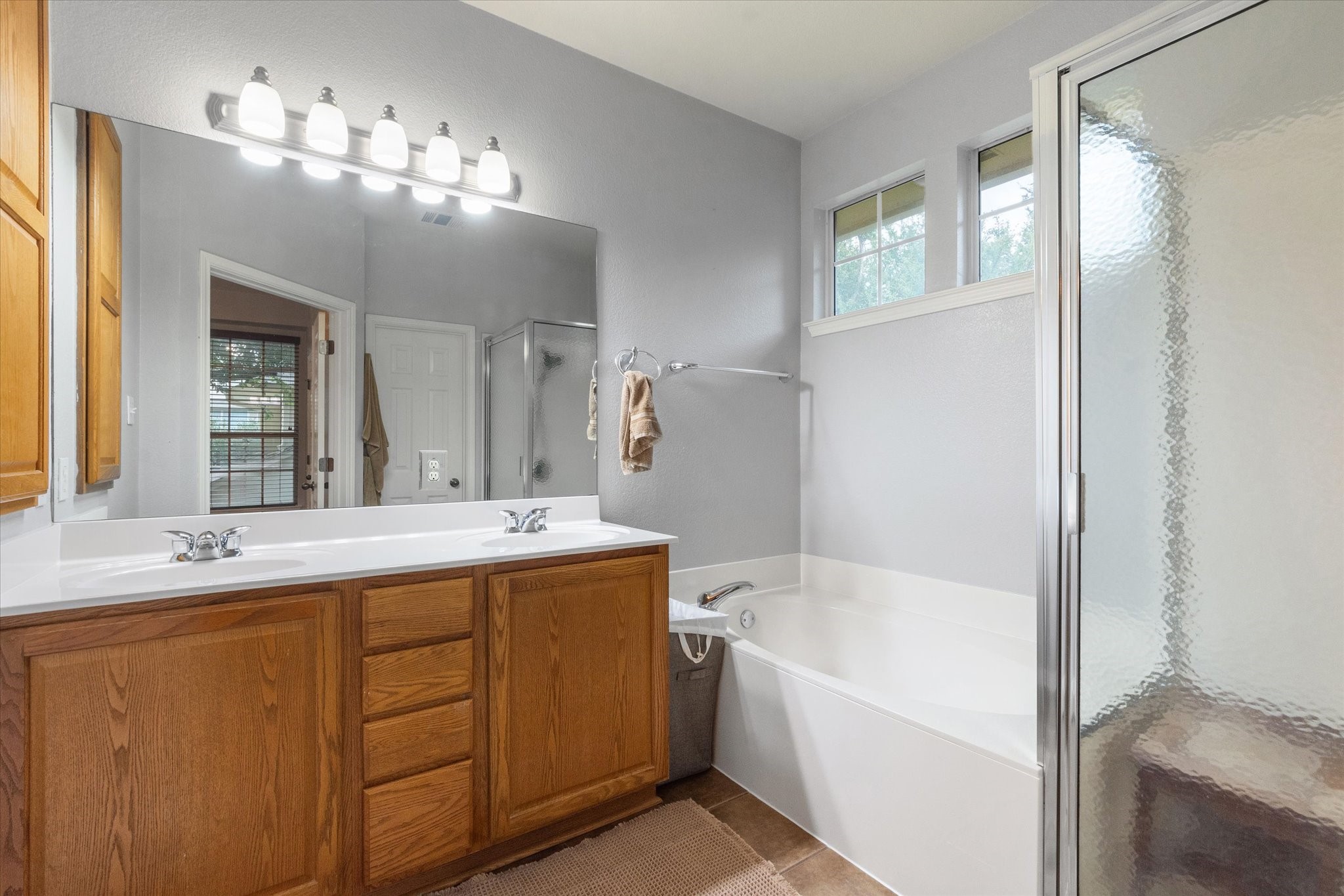 11000 Anderson Mill Road, Unit 34 Austin, TX 78750 - Photo 10 of 18 a bathroom with a tub a sink and mirror