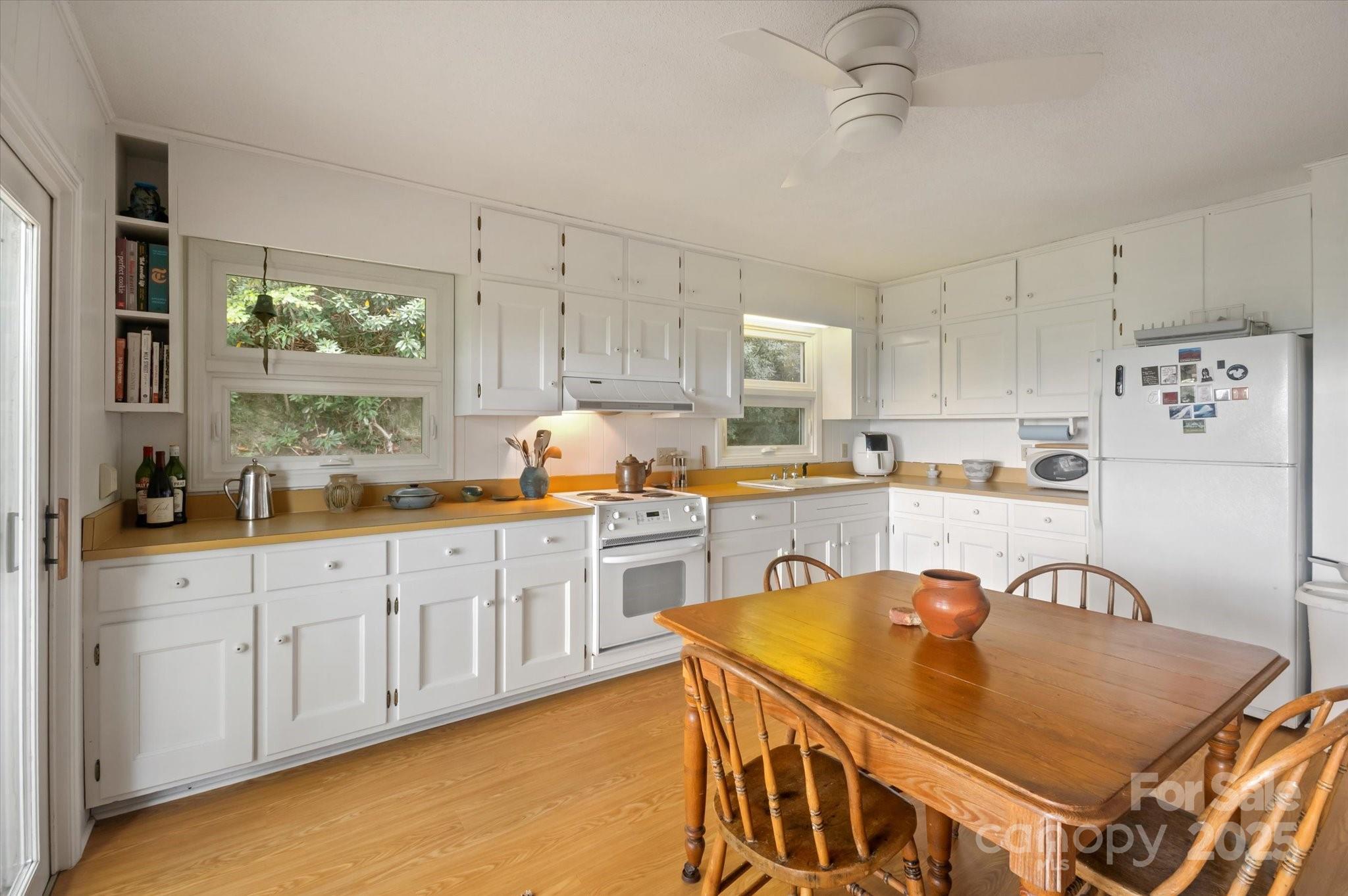 909 Green Hill Road Brevard, NC 28712 - Photo 14 of 44 a open kitchen with stainless steel appliances granite countertop a stove a sink a refrigerator white cabinets and wooden floor