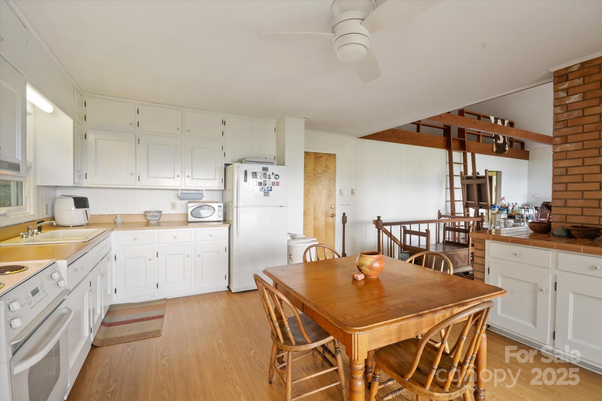 909 Green Hill Road Brevard, NC 28712 - Photo 15 of 44 a kitchen with stainless steel appliances granite countertop a sink a stove a dining table and chairs