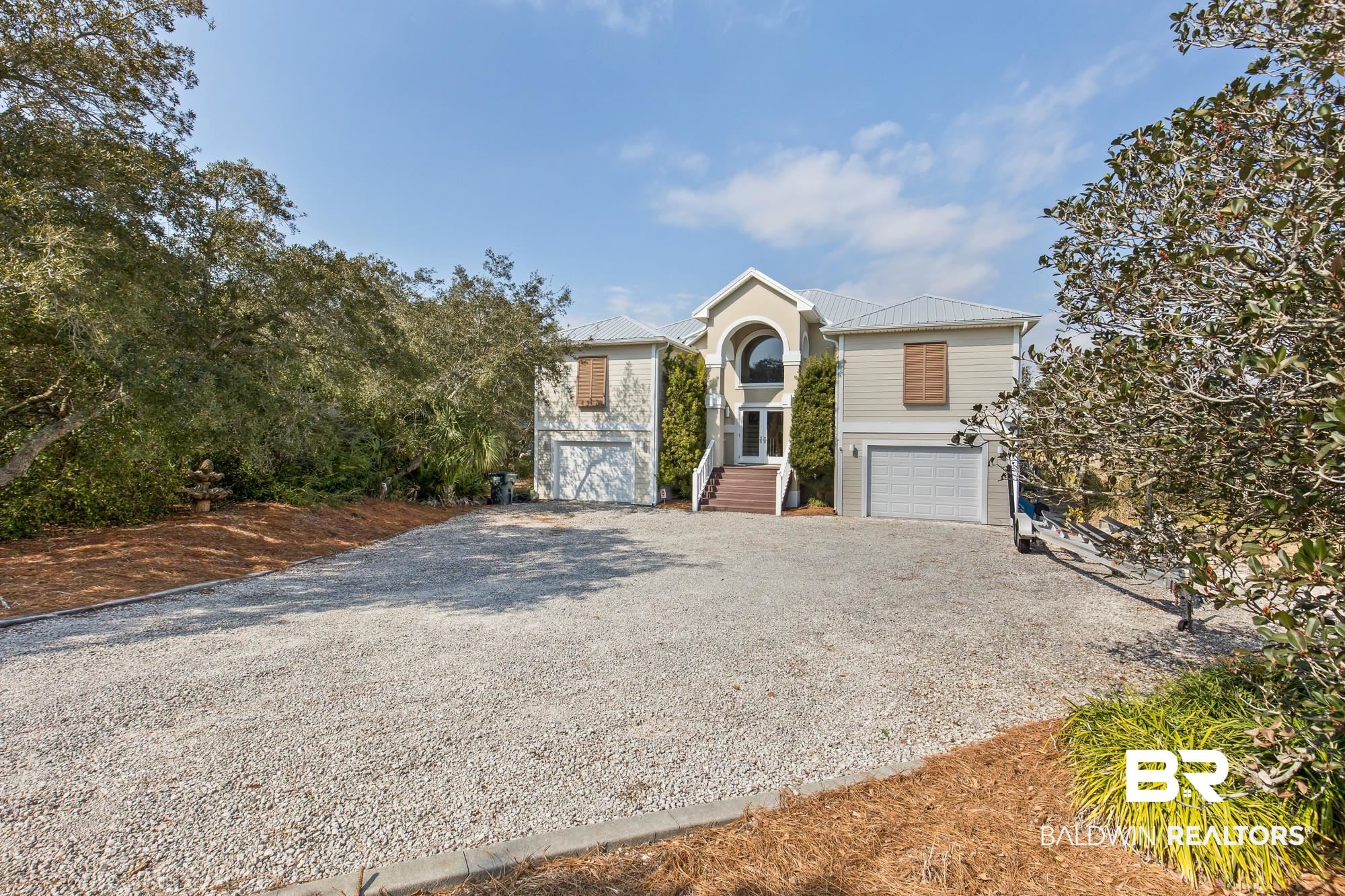 32191 River Road Orange Beach, AL 36561 - Photo 2 of 46 View of front of home with driveway, a garage, and a metal roof