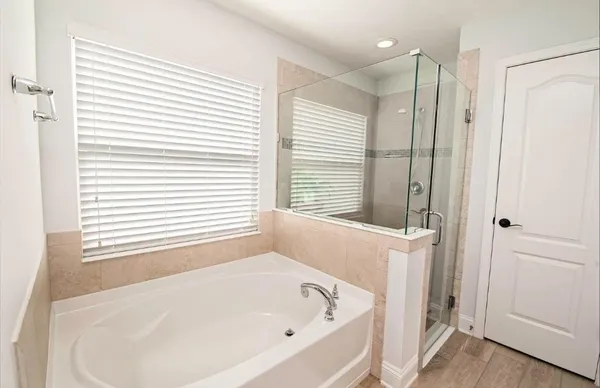 a white bath tub sitting in a bathroom next to a window