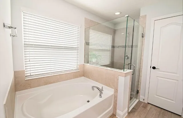 a white bath tub sitting in a bathroom next to a window