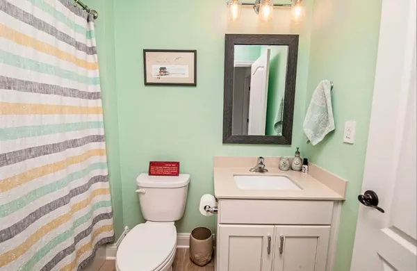 a bathroom with a toilet sink vanity and mirror