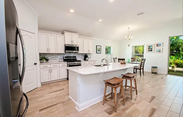 a kitchen with white cabinets and stainless steel appliances