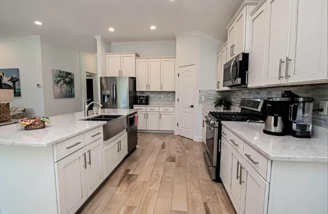 a kitchen with white cabinets sink and stainless steel appliances