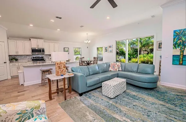 a living room with stainless steel appliances furniture and a view of kitchen