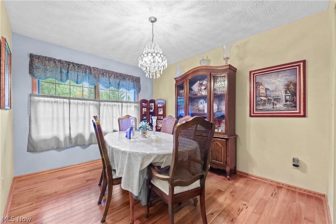 1835 Lynn Road Kent, OH 44240 - Photo 13 of 48 Dining area featuring wood-finish flooring, a crystal chandelier, and large windows