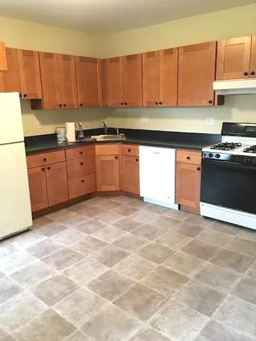 a kitchen with stainless steel appliances granite countertop a stove a sink and a refrigerator