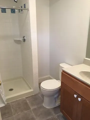 a bathroom with a toilet and a shower