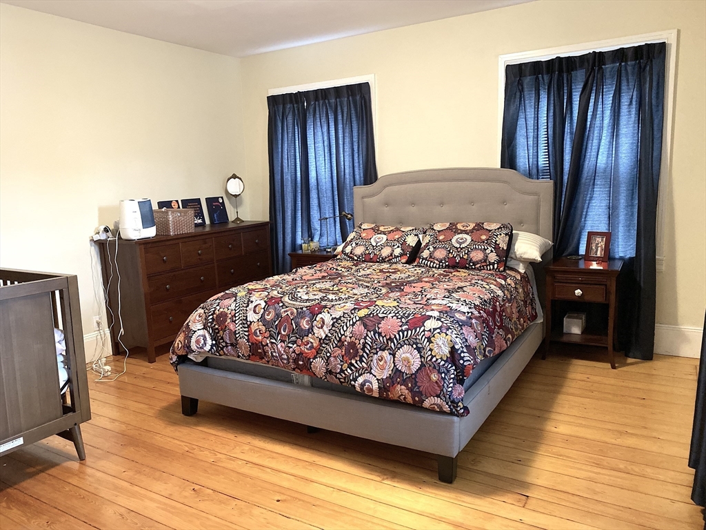 11 Lanark Road, Unit 1 Brookline, MA 02445 - Photo 7 of 11 a bed sitting in a bedroom next to a wooden floor