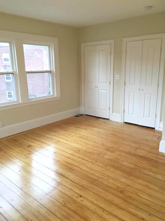 11 Lanark Road, Unit 1 Brookline, MA 02445 - Photo 8 of 11 a view of an empty room with wooden floor and a window