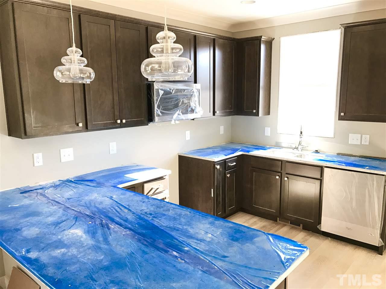 809 East Lenoir Street Raleigh, NC 27601 - Photo 5 of 20 a kitchen with granite countertop a sink cabinets and wooden floor