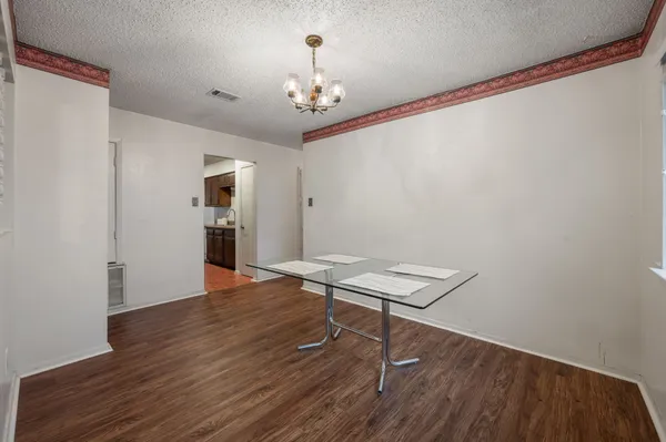 a view of a room with wooden floor and chandelier