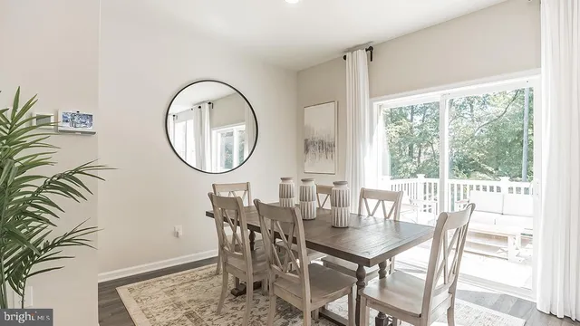 a dining room with furniture a rug and a floor to ceiling window