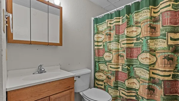 a bathroom with a granite countertop toilet and a sink