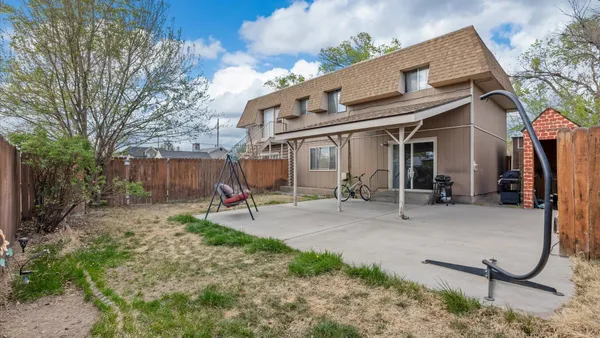 a view of a house with backyard and chairs
