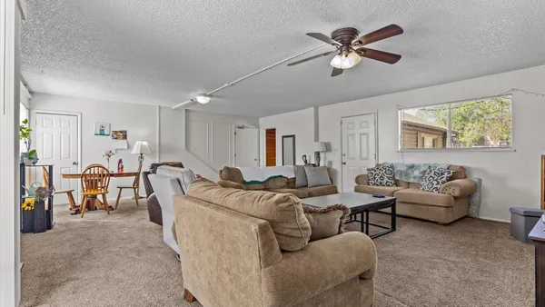 a living room with furniture and a ceiling fan