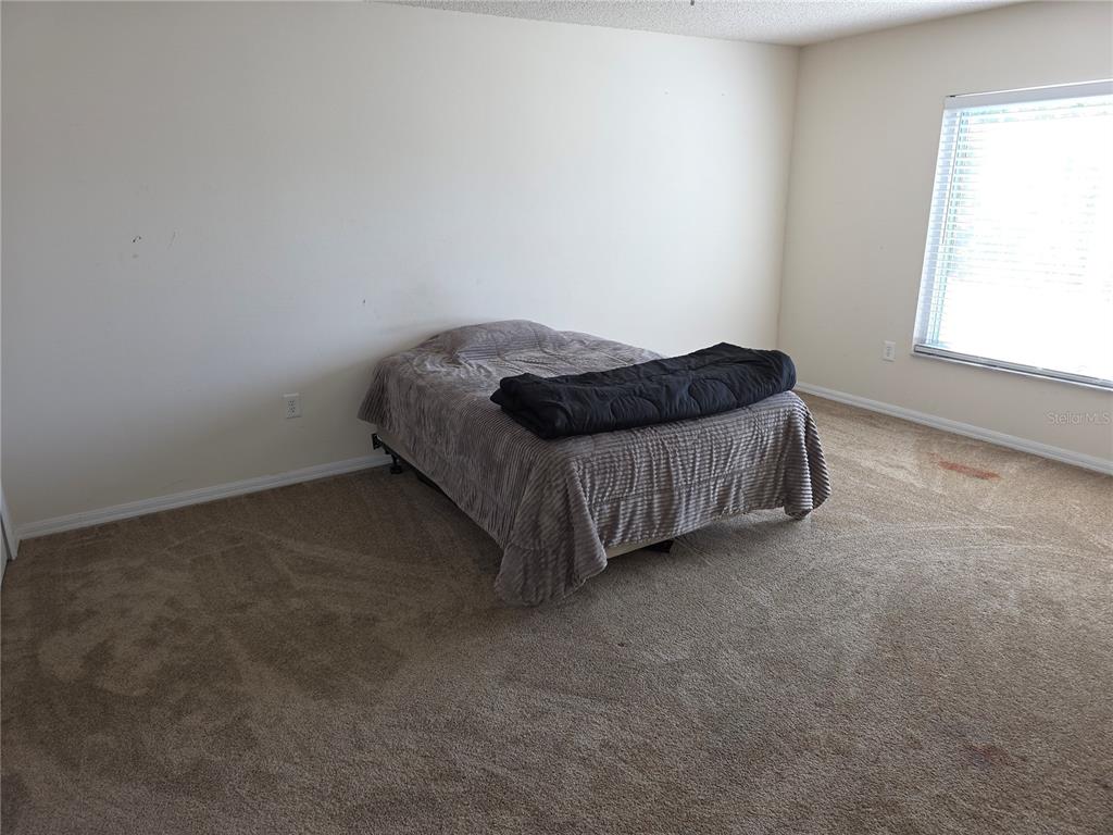 8388 Maltby Road Spring Hill, FL 34606 - Photo 17 of 28 a bed sitting in a room next to a window