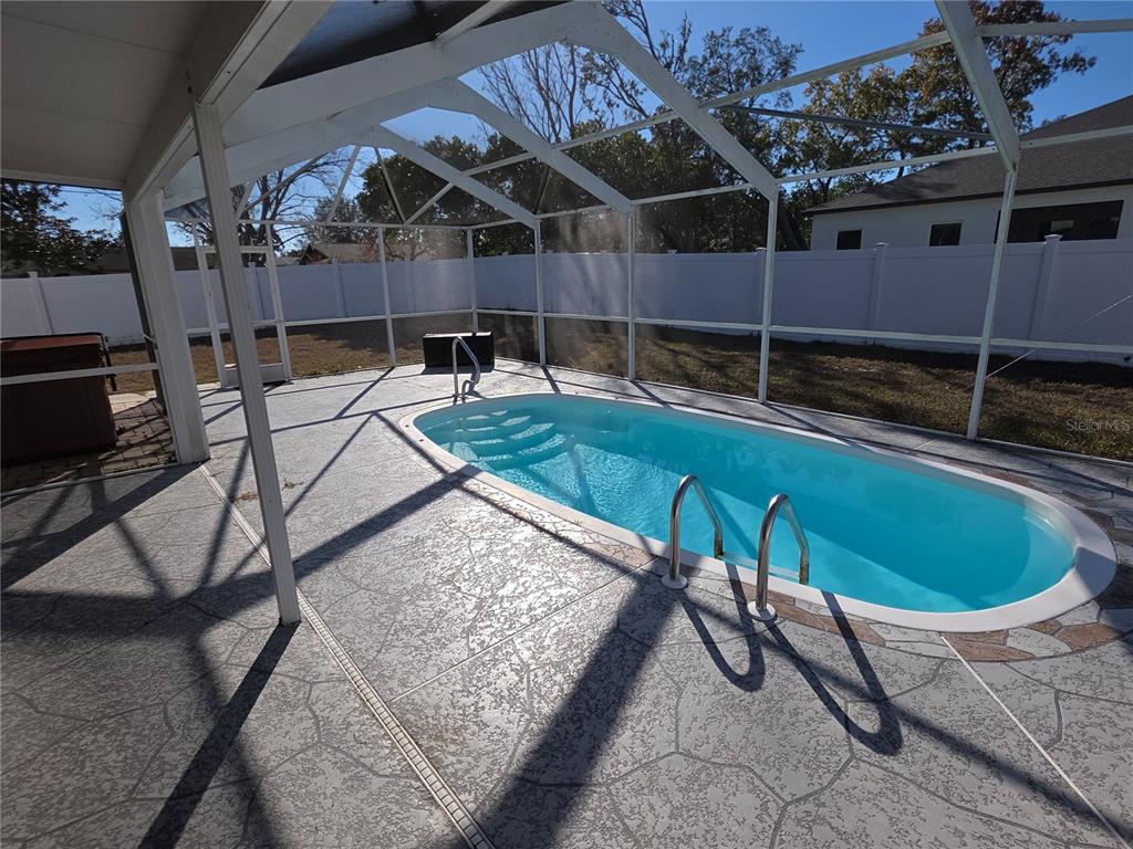 8388 Maltby Road Spring Hill, FL 34606 - Photo 25 of 28 a view of a backyard with table and chairs with wooden fence